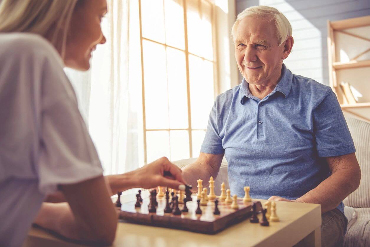 A woman and an old man playing chess